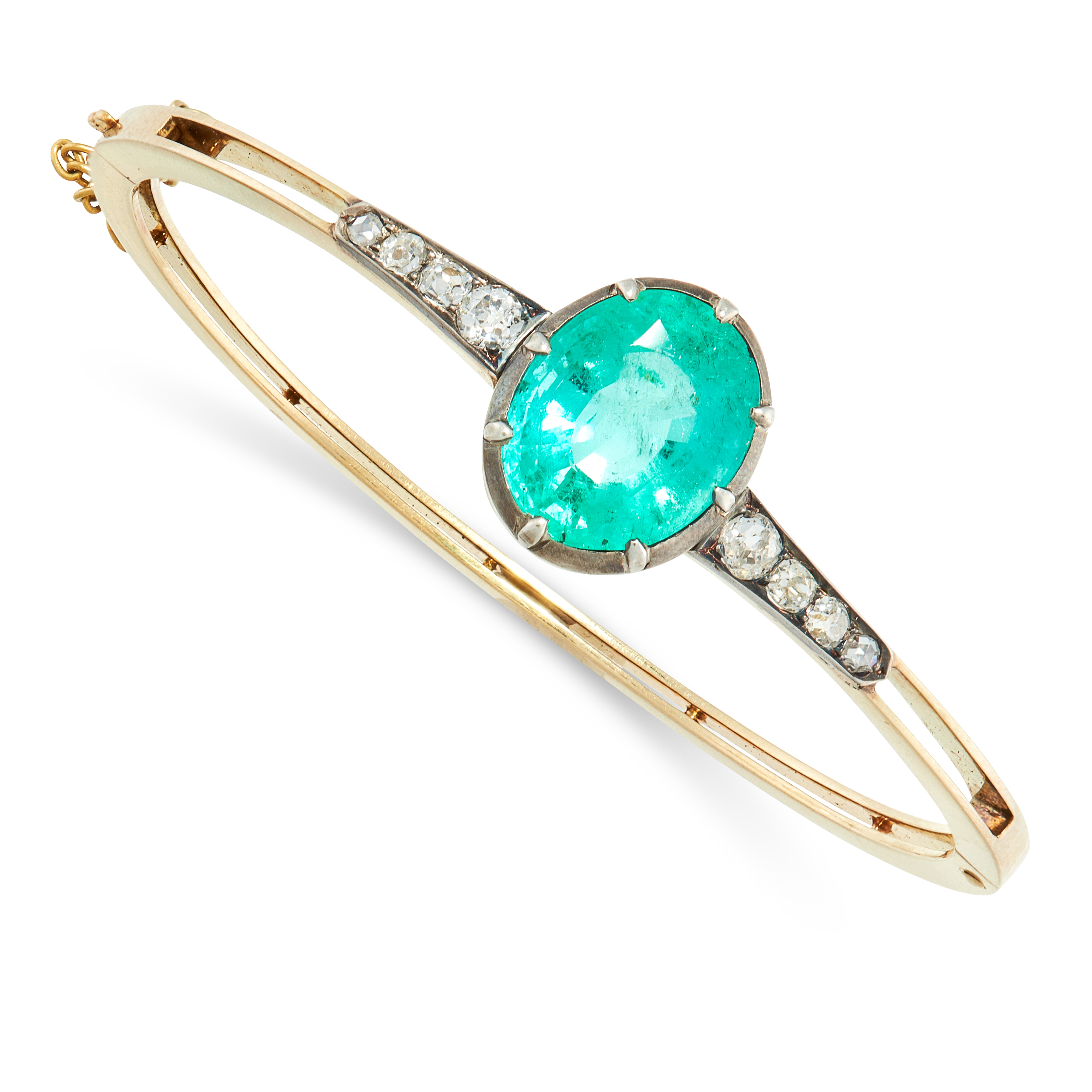 A COLOMBIAN EMERALD AND DIAMOND BANGLE in yellow gold and silver, set with an oval cut emerald of