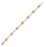 A SAPPHIRE AND DIAMOND BRACELET in 18ct yellow gold, set with seven oval cut blue sapphires accented