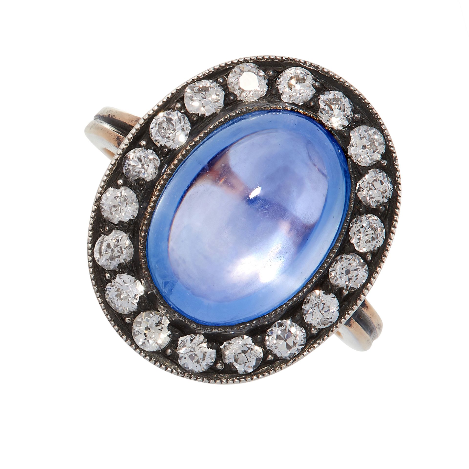 A CEYLON NO HEAT SAPPHIRE AND DIAMOND RING in yellow gold and silver, set with an oval cabochon blue