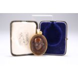 A CARVED MULBERRY WOOD DOUBLE CAMEO PENDANT