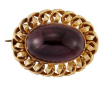 A VICTORIAN GARNET BROOCH, an oval cabochon garnet in a rub-over setting within a scroll frame, with