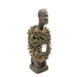 A carved tribal figure embellished with nails and mirror glass to the front, 38cm high
