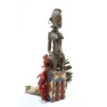 A large carved and painted tribal figure, hung with beads and with hoops in the ears, 67.5cm high