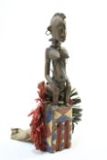 A large carved and painted tribal figure, hung with beads and with hoops in the ears, 67.5cm high