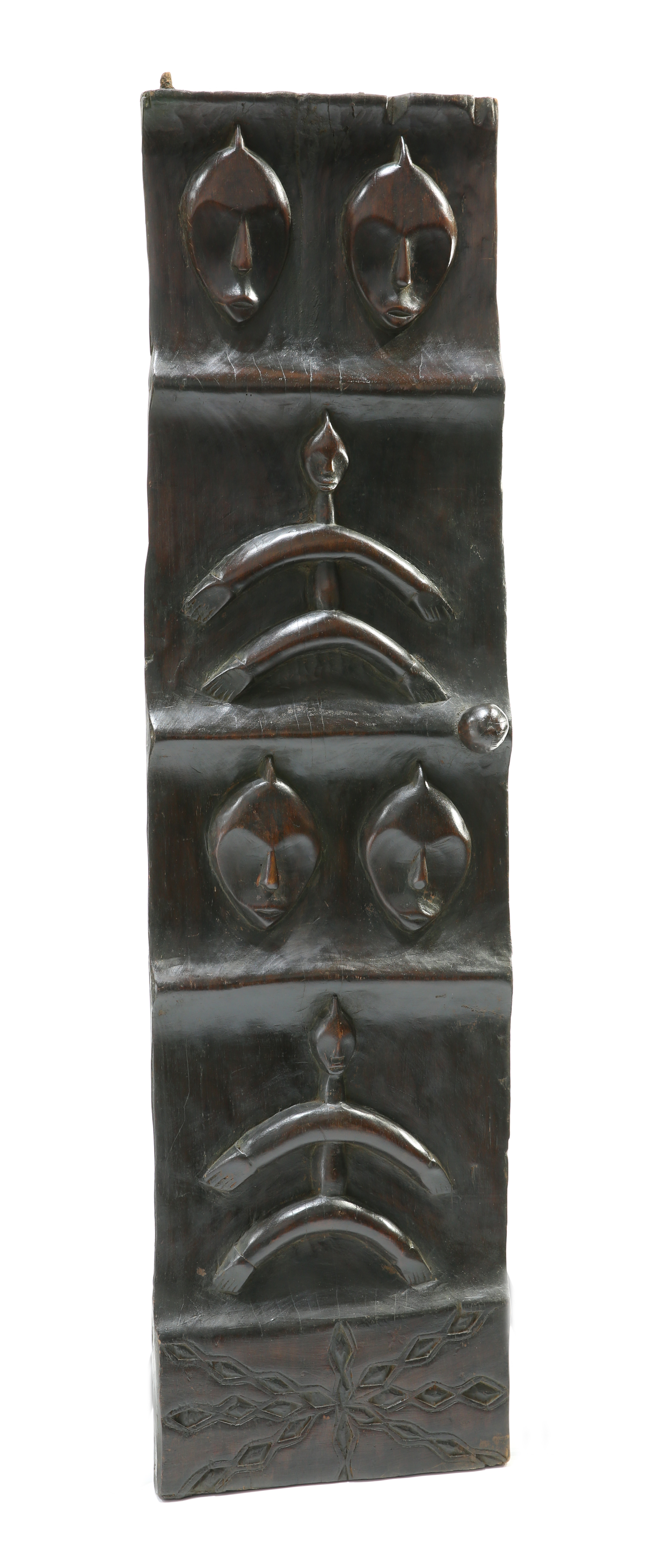 A tribal carved panel depicting masks and stylised figures, 139.5cm high