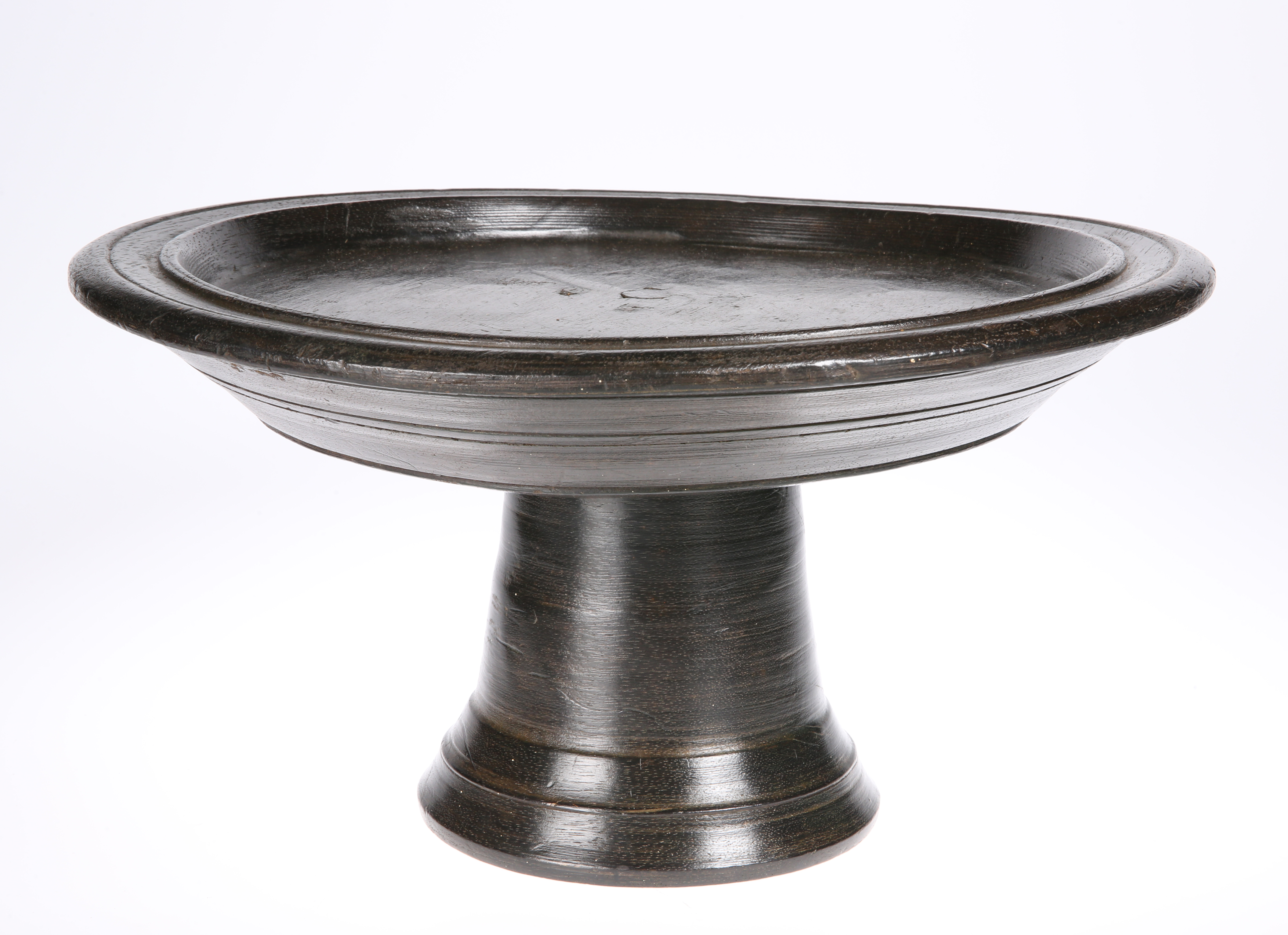 A tribal carved footed bowl, 36cm diameter