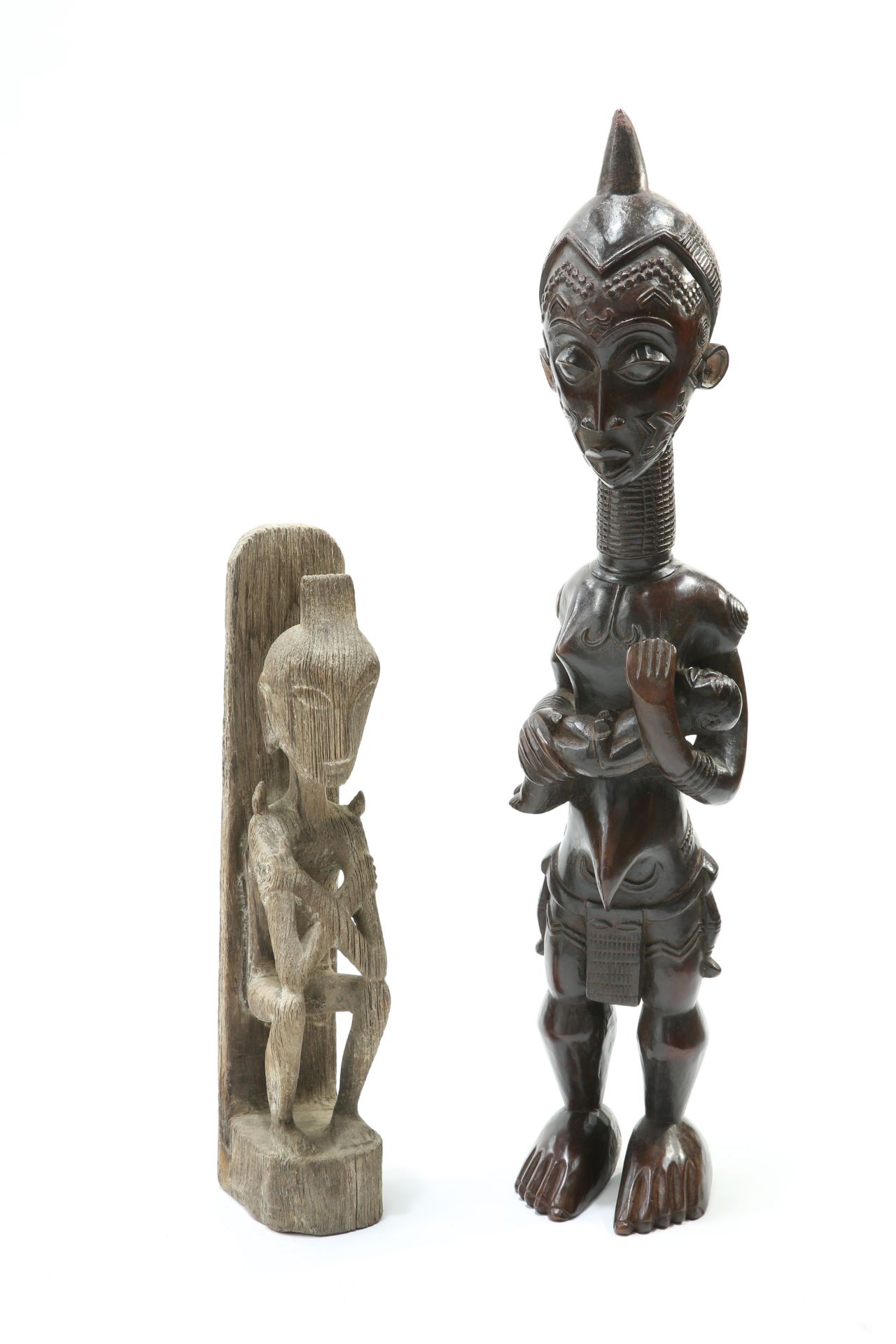Two tribal carved figures, the first modelled as a mother and child, the first 72cm high