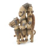 A carved tribal figure group of two figures riding a mule, 46cm high