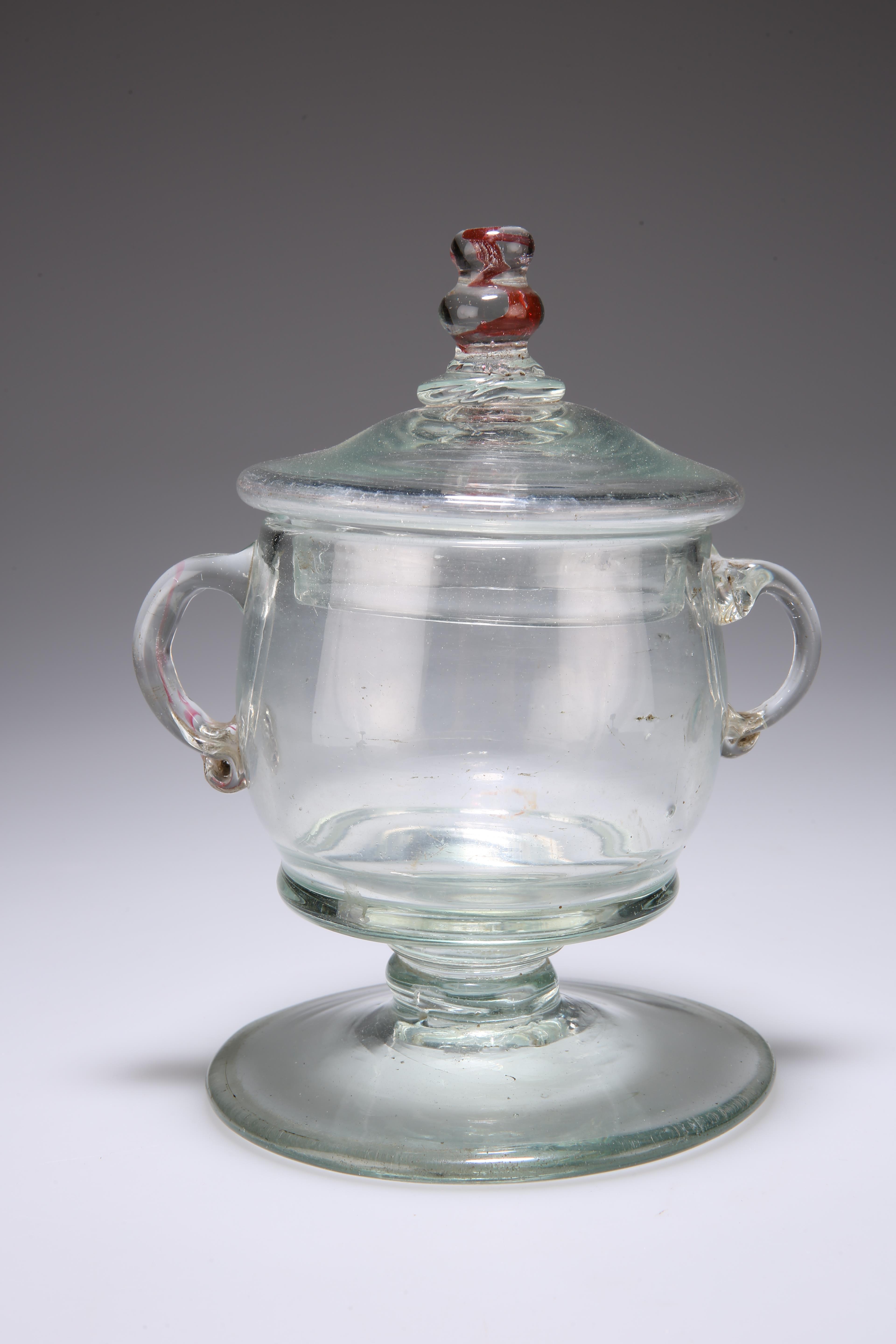 A CONTINENTAL GLASS LIDDED JAR, 18TH CENTURY, the domed cover with knopped finial with red