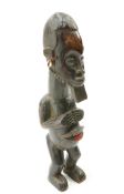 A tribal carved figure with shells hanging from the ears, 45cm high