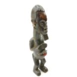 A tribal carved figure with shells hanging from the ears, 45cm high