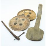 Two shields; together with an axe and a paddle, length of axe 58cm