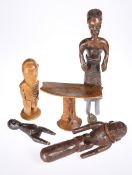 Five tribal carvings including a head rest and figures, tallest 40.5cm