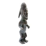 A carved tribal figure with mirrored eyes and applied brass studs, 57cm high