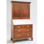 A GEORGE II OAK BUREAU BOOKCASE, the upper section with projecting dentil cornice above a pair of