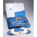 A CHINESE BOXED SET OF BLUE SILK PYJAMAS, GOWN AND SLIPPERS, worked in relief with coloured