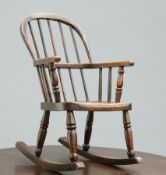 A 19TH CENTURY ELM AND OAK CHILDS ROCKING CHAIR, with spindle back and well figured seat. 66cm high