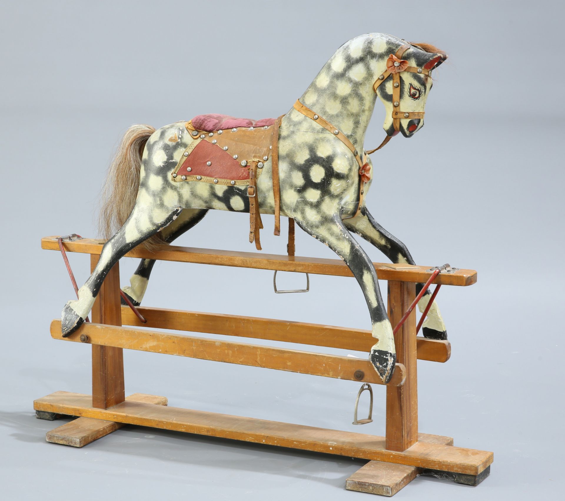 A SMALL PAINTED AND CARVED ROCKING HORSE