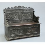 A VICTORIAN CARVED OAK BOX SETTLE