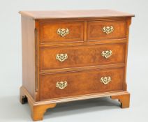 A GEORGIAN STYLE CROSSBANDED AND FEATHER BANDED BURR YEW CHEST OF DRAWERS