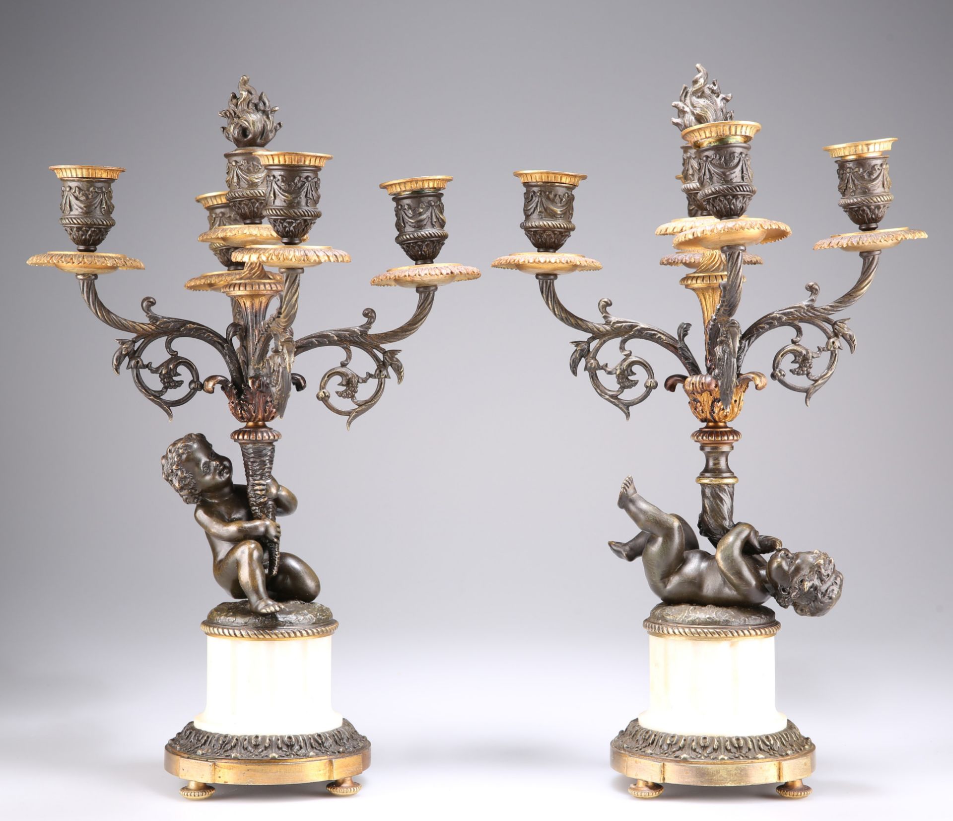 A PAIR OF FRENCH PATINATED BRONZE AND PARCEL-GILT FOUR-LIGHT CANDELABRA