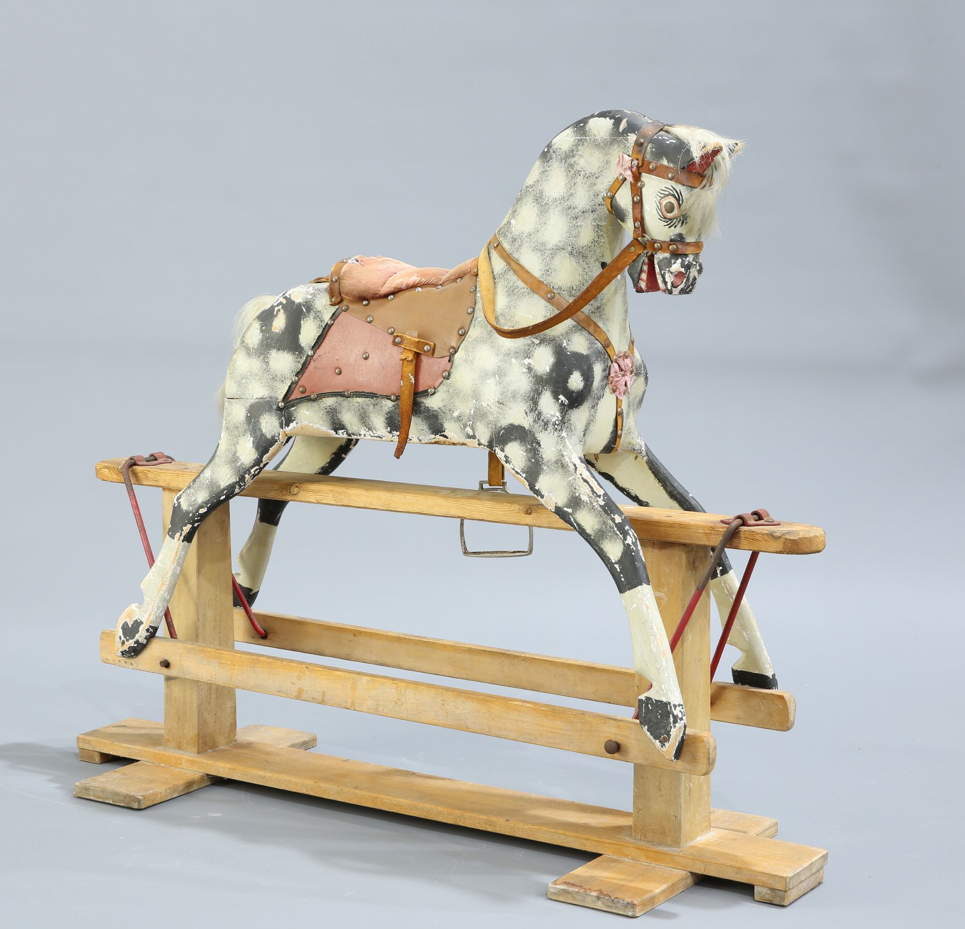 A PAINTED AND CARVED ROCKING HORSE