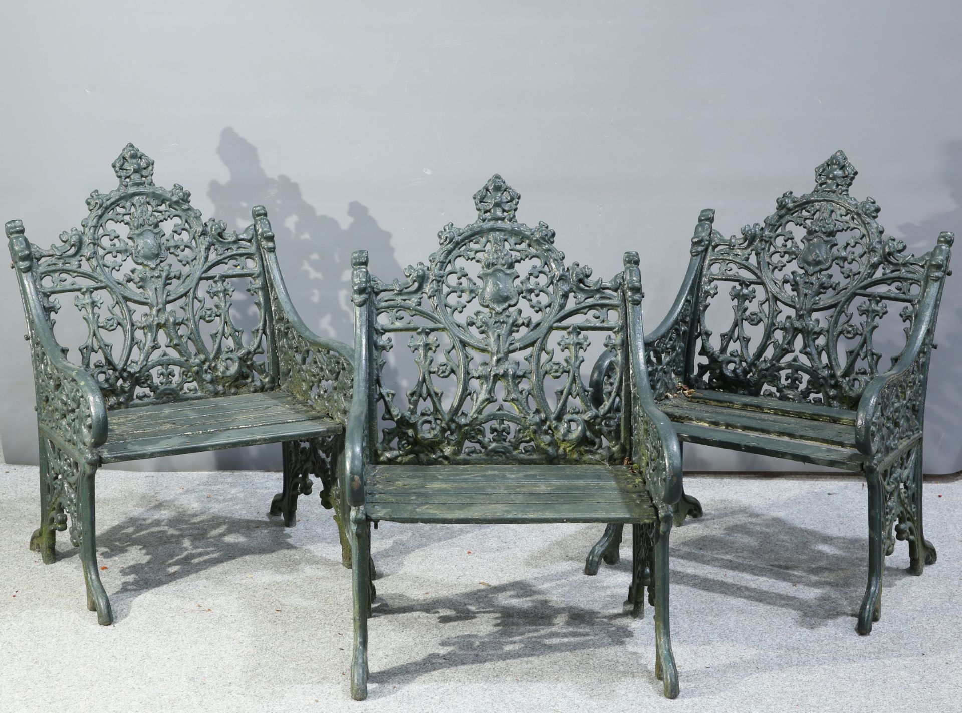 A SET OF THREE GREEN PAINTED CAST IRON GARDEN CHAIRS
