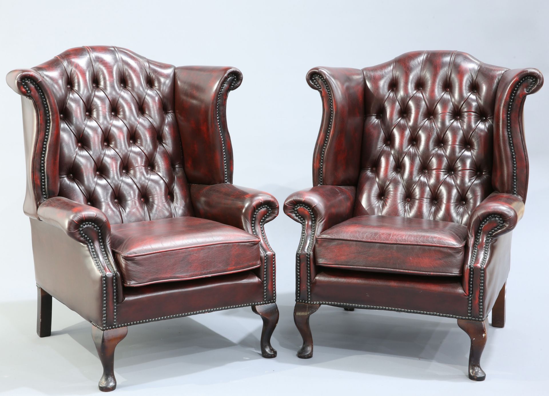 A PAIR OF OXBLOOD LEATHER WING BACK ARMCHAIRS