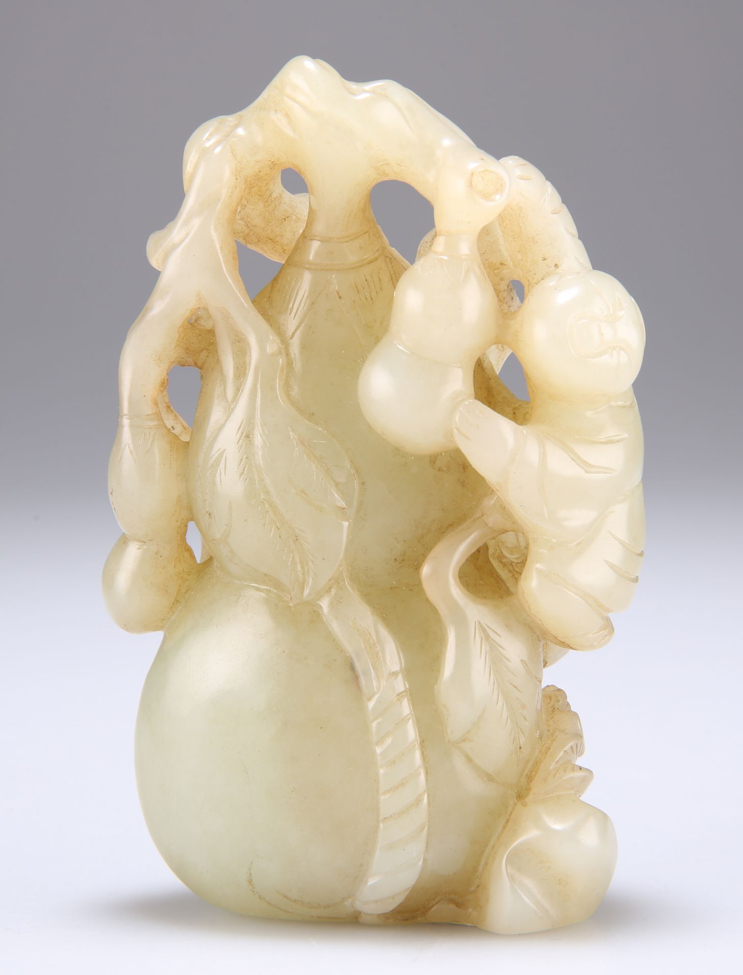 A CHINESE CELADON JADE CARVING OF A GOURD