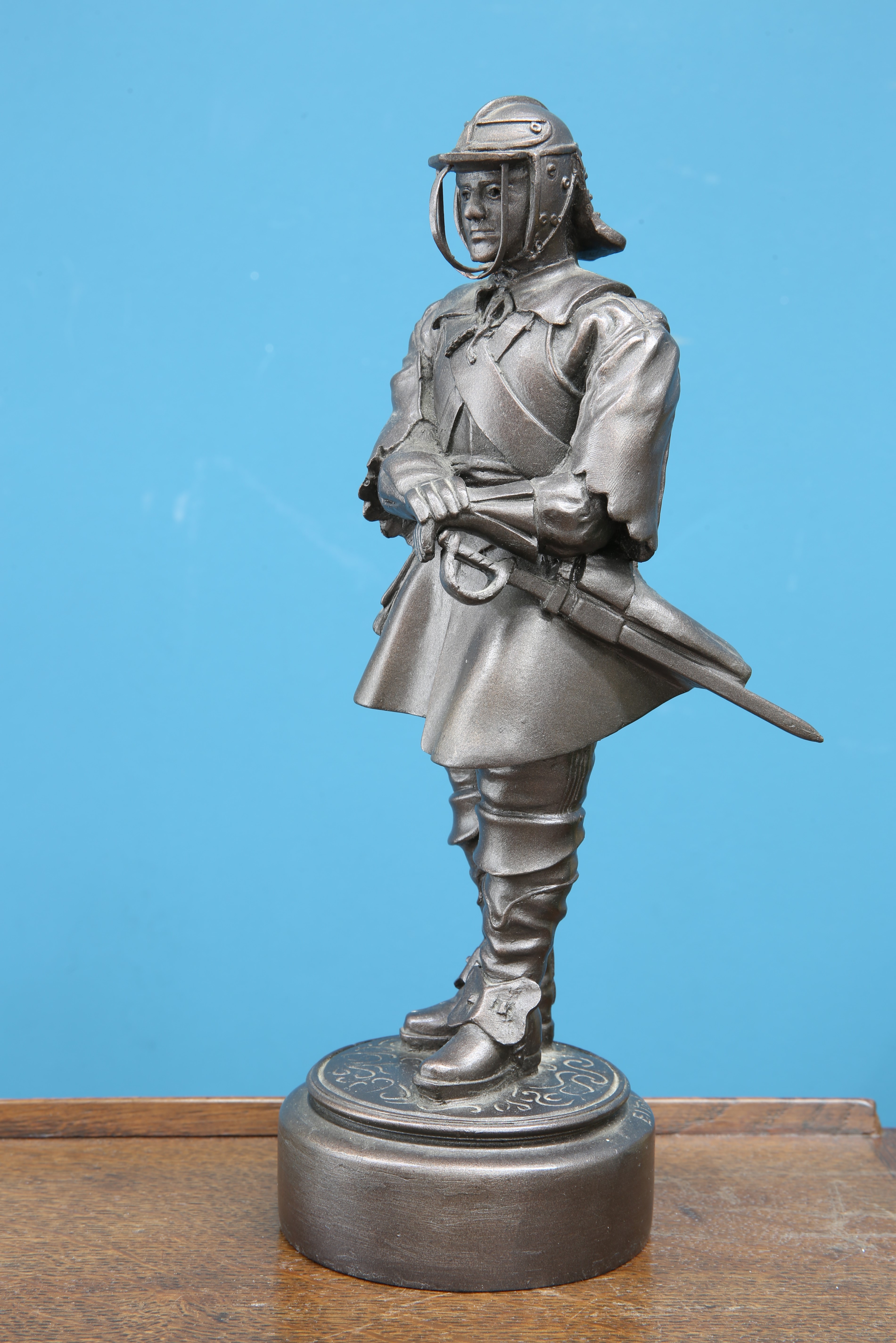 A BRONZED SCULPTURE OF A MILITARY FIGURE