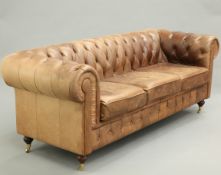 A LARGE BROWN LEATHER CHESTERFIELD SETTEE