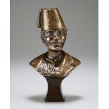 A CAST BRONZE HEAD AND SHOULDERS STUDY OF A MOUSTACHIOED MALE WEARING A FEZ