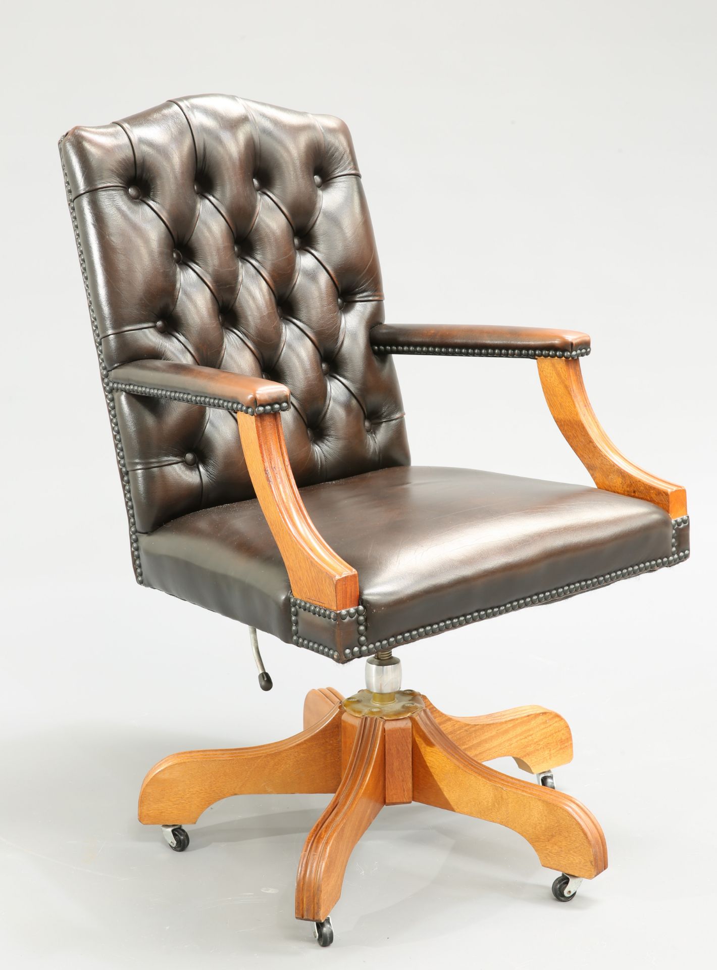 A BUTTONED BACK BROWN LEATHER SWIVEL DESK CHAIR