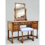 A PERIOD STYLE OAK DRESSING TABLE AND FOOTSTOOL BY TITCHMARSH AND GOODWIN