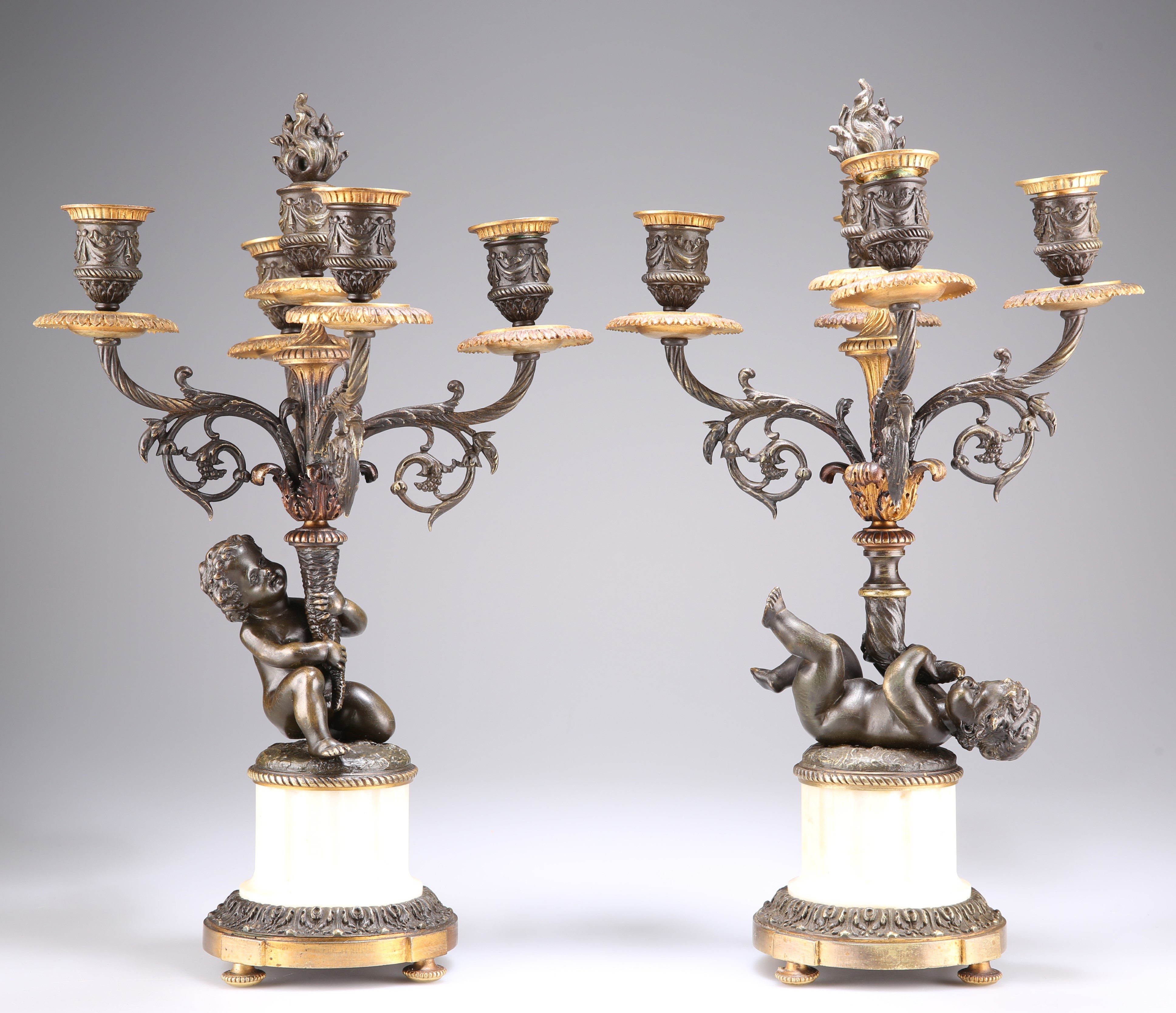 A PAIR OF FRENCH PATINATED BRONZE AND PARCEL-GILT