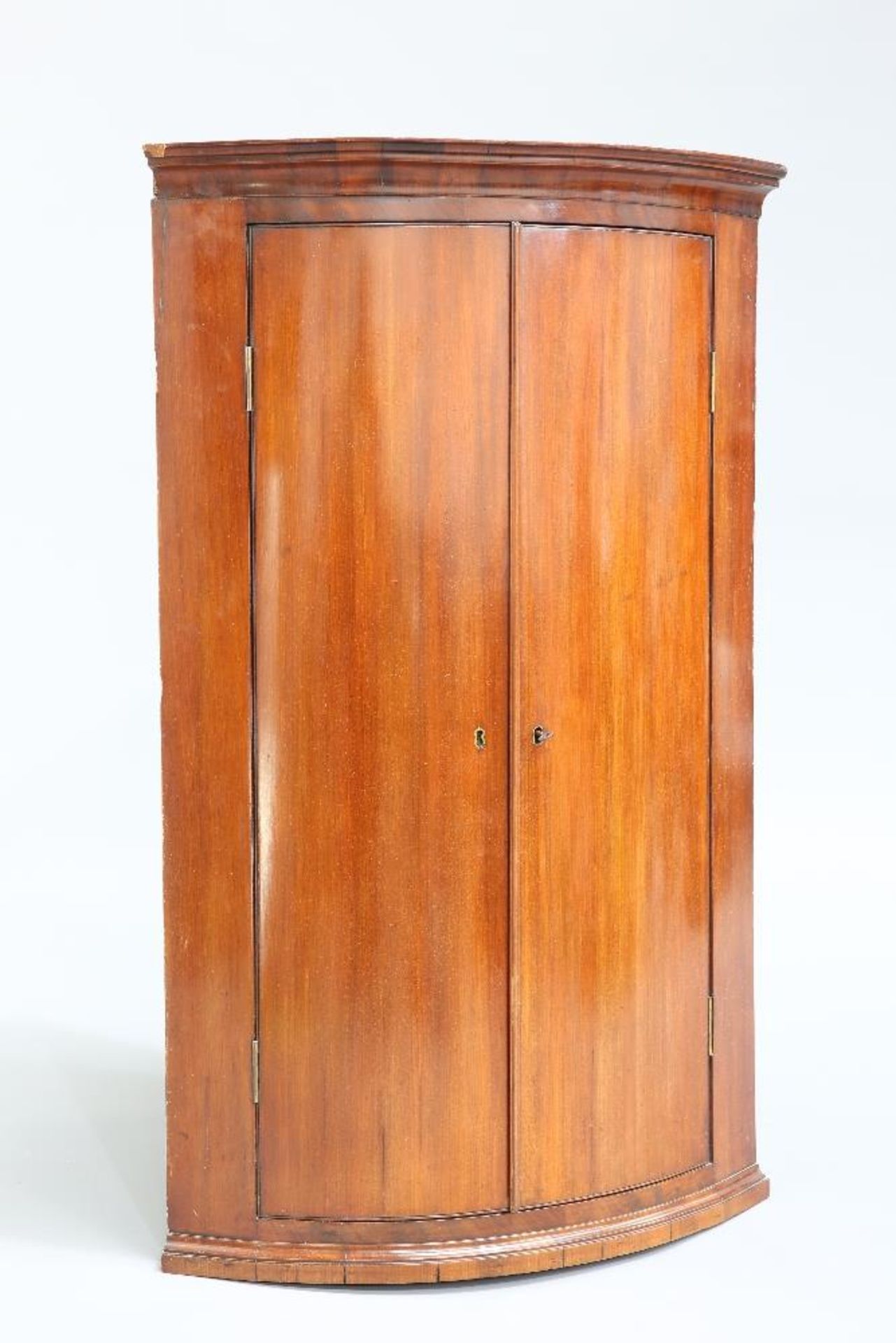 A GEORGE III MAHOGANY BOW FRONTED HANGING CORNER CUPBOARD