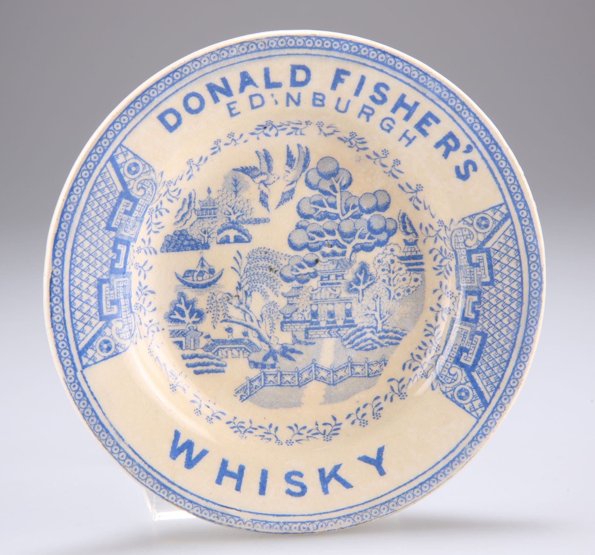 ADVERTISING INTEREST: A BLUE TRANSFER-PRINTED WILLOW PATTERN POTTERY DISH