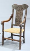 A LATE VICTORIAN CARVED OAK OPEN ARMCHAIR