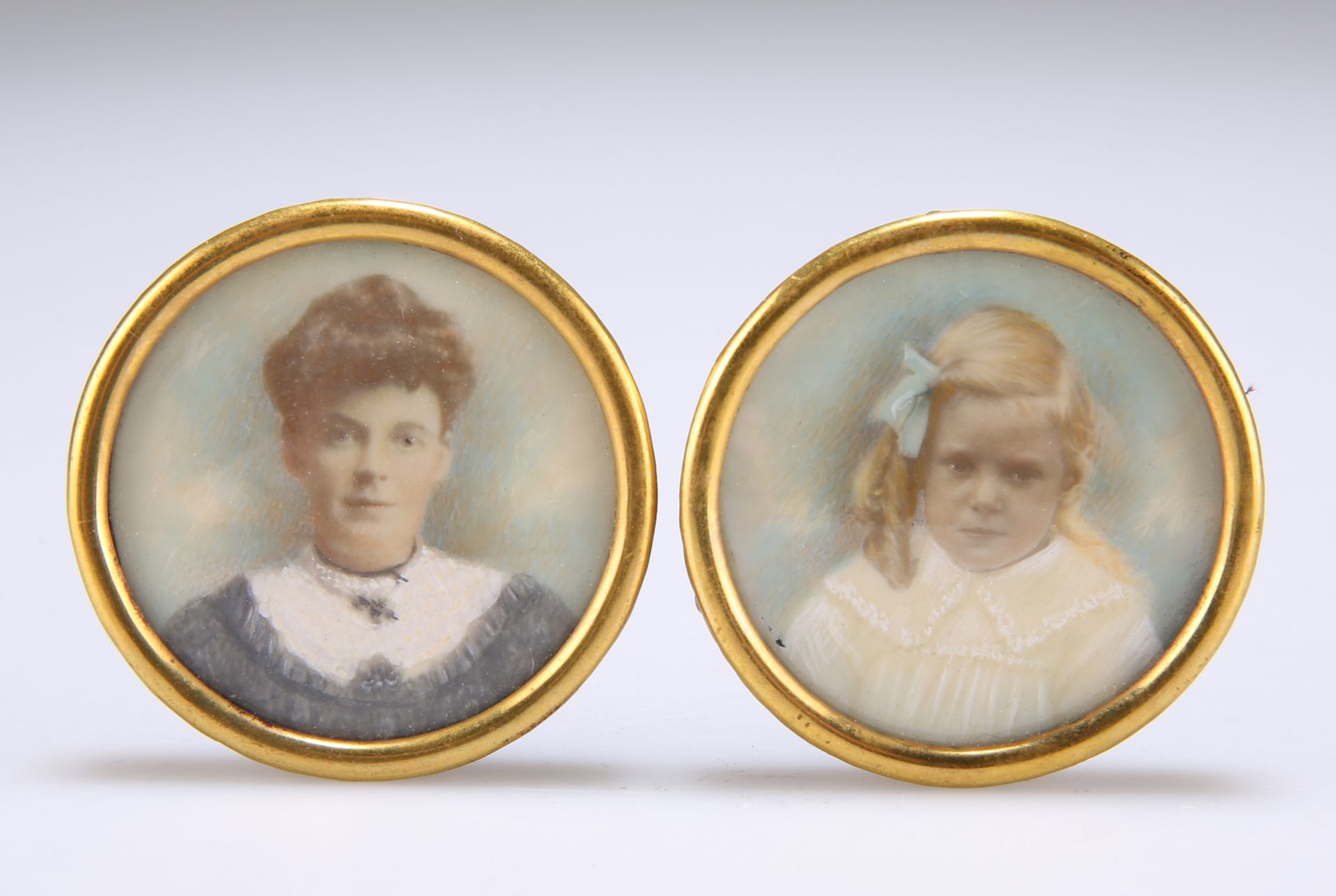 A PAIR OF EARLY 20TH CENTURY PORTRAIT MINIATURES ON IVORY