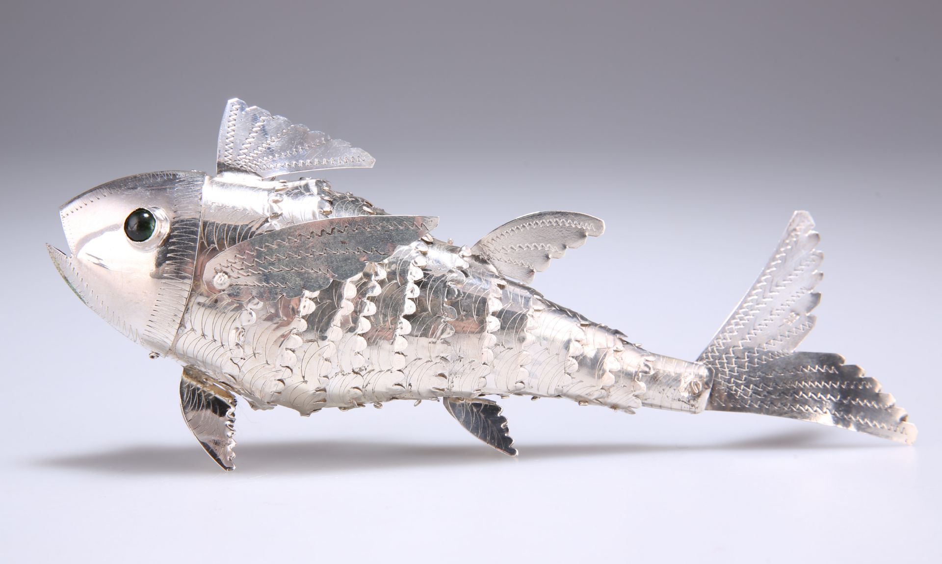 AN ARTICULATED SILVER METAL MODEL OF A FISH