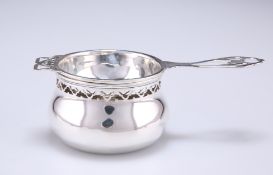 A GEORGE V SILVER TEA STRAINER ON STAND