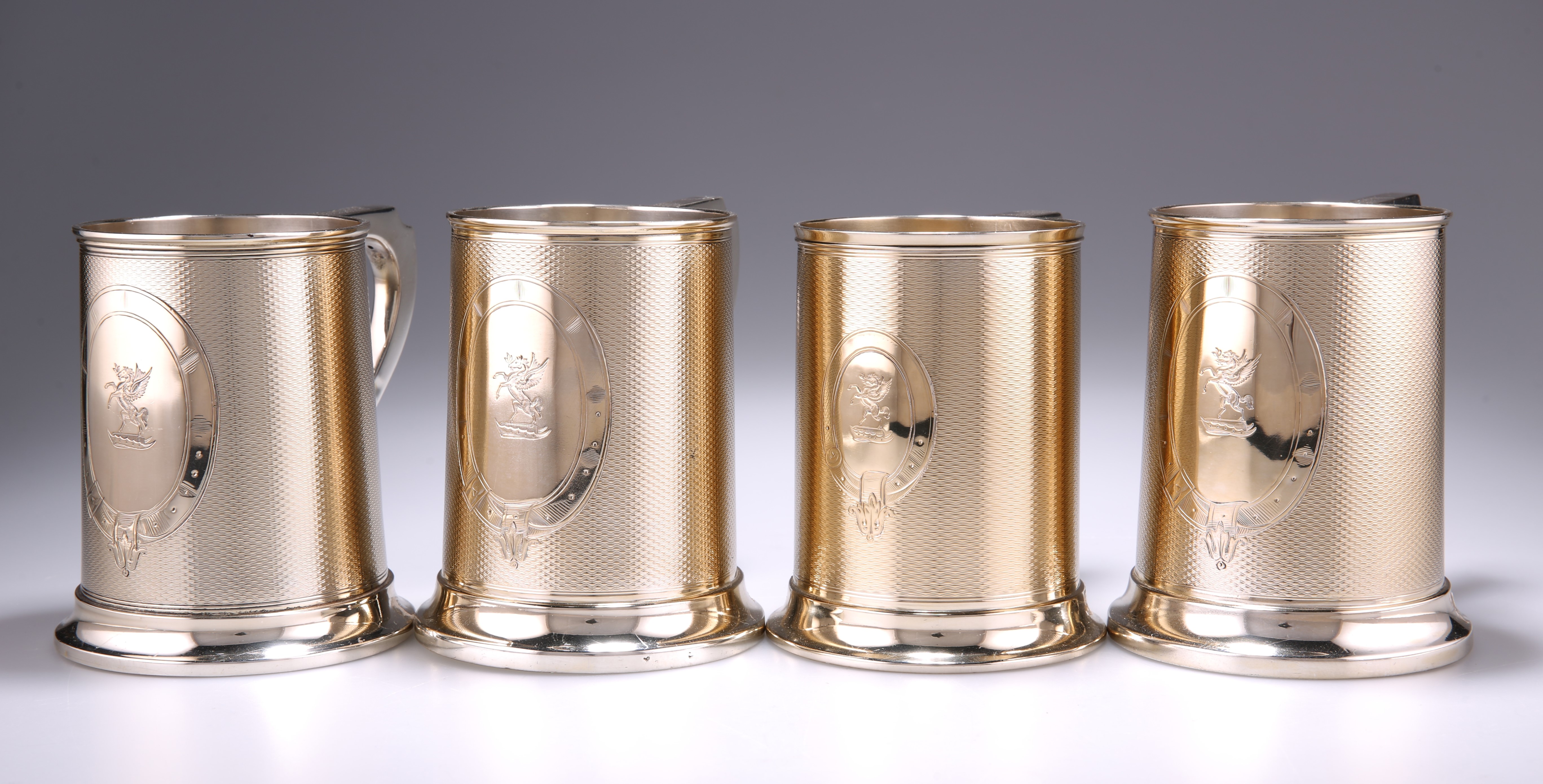 A HARLEQUIN SET OF FOUR VICTORIAN SILVER-GILT PINT MUGS