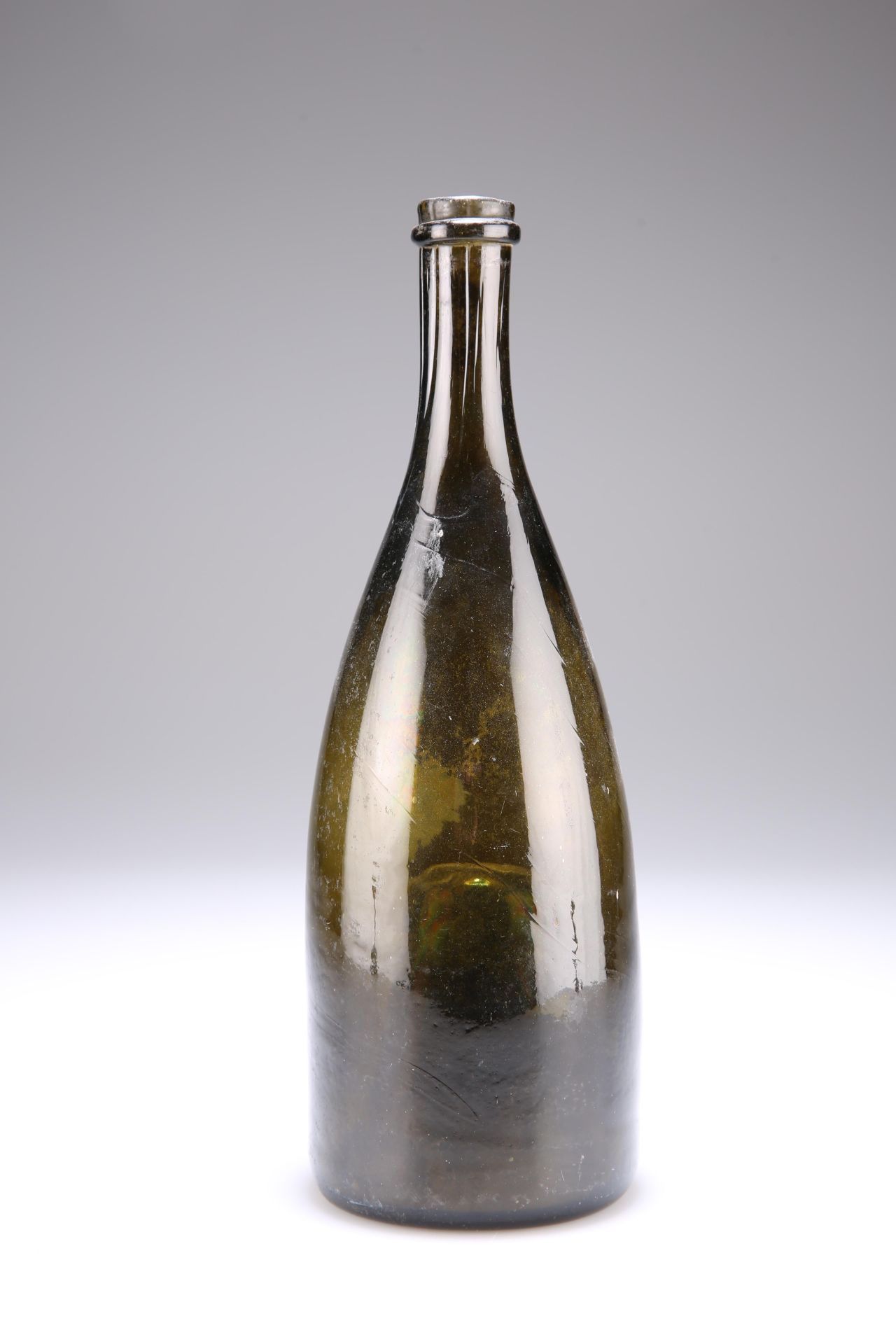 A MID-19TH CENTURY GREEN GLASS WINE BOTTLE, with partially fluted neck and unusually deep kick-in