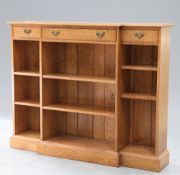 AN EDWARDIAN STYLE LIGHT OAK BREAKFRONT OPEN BOOKCASE