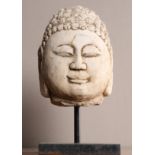 A CHINESE CARVED LIMESTONE HEAD OF BUDDHA