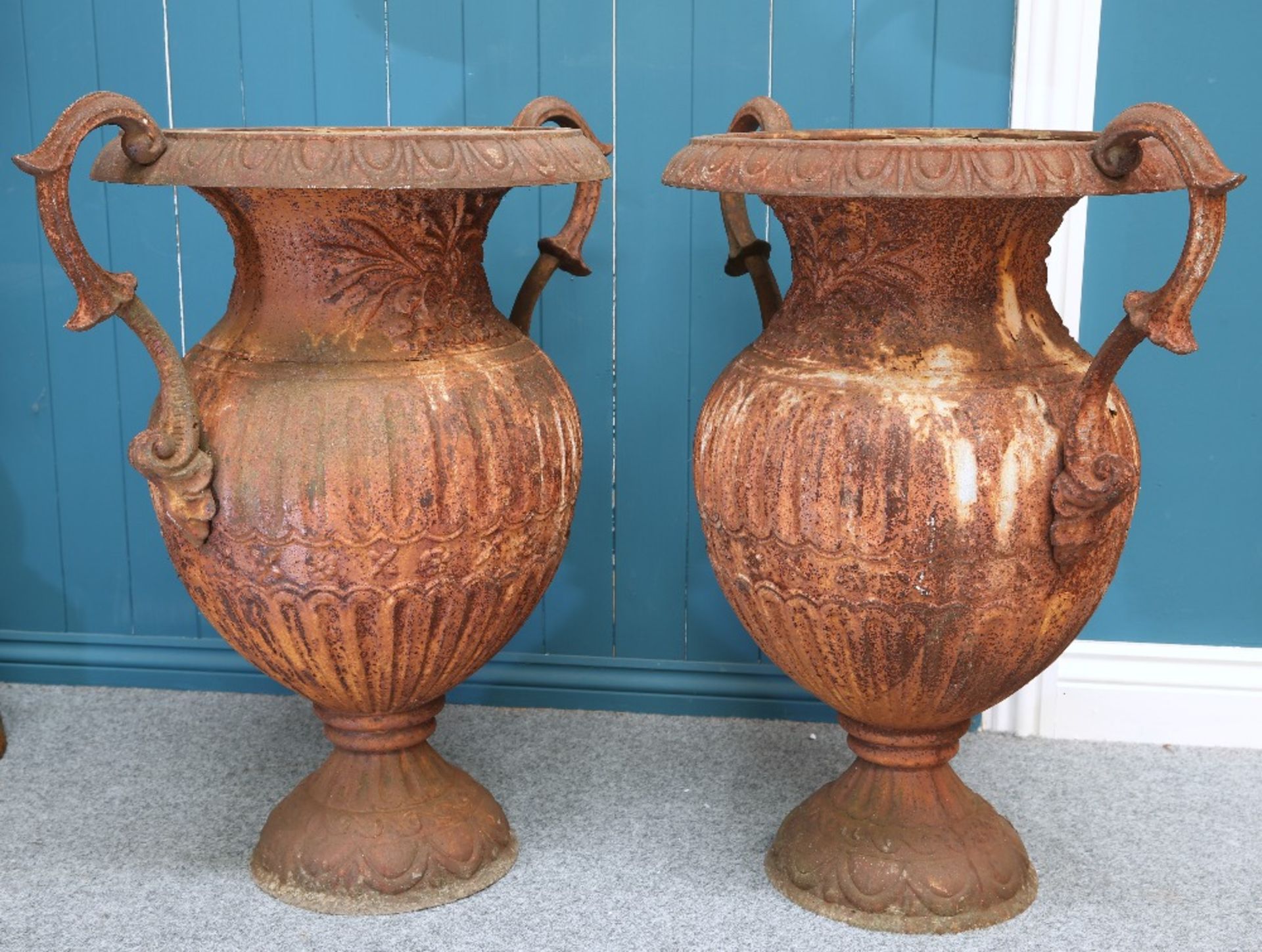 A LARGE PAIR OF CAST IRON TWO-HANDLED URNS