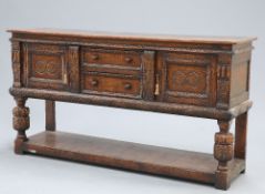 A JACOBEAN STYLE CARVED OAK DRESSER BASE, PROBABLY BY TITCHMARSH AND GOODWIN