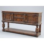 A JACOBEAN STYLE CARVED OAK DRESSER BASE, PROBABLY BY TITCHMARSH AND GOODWIN