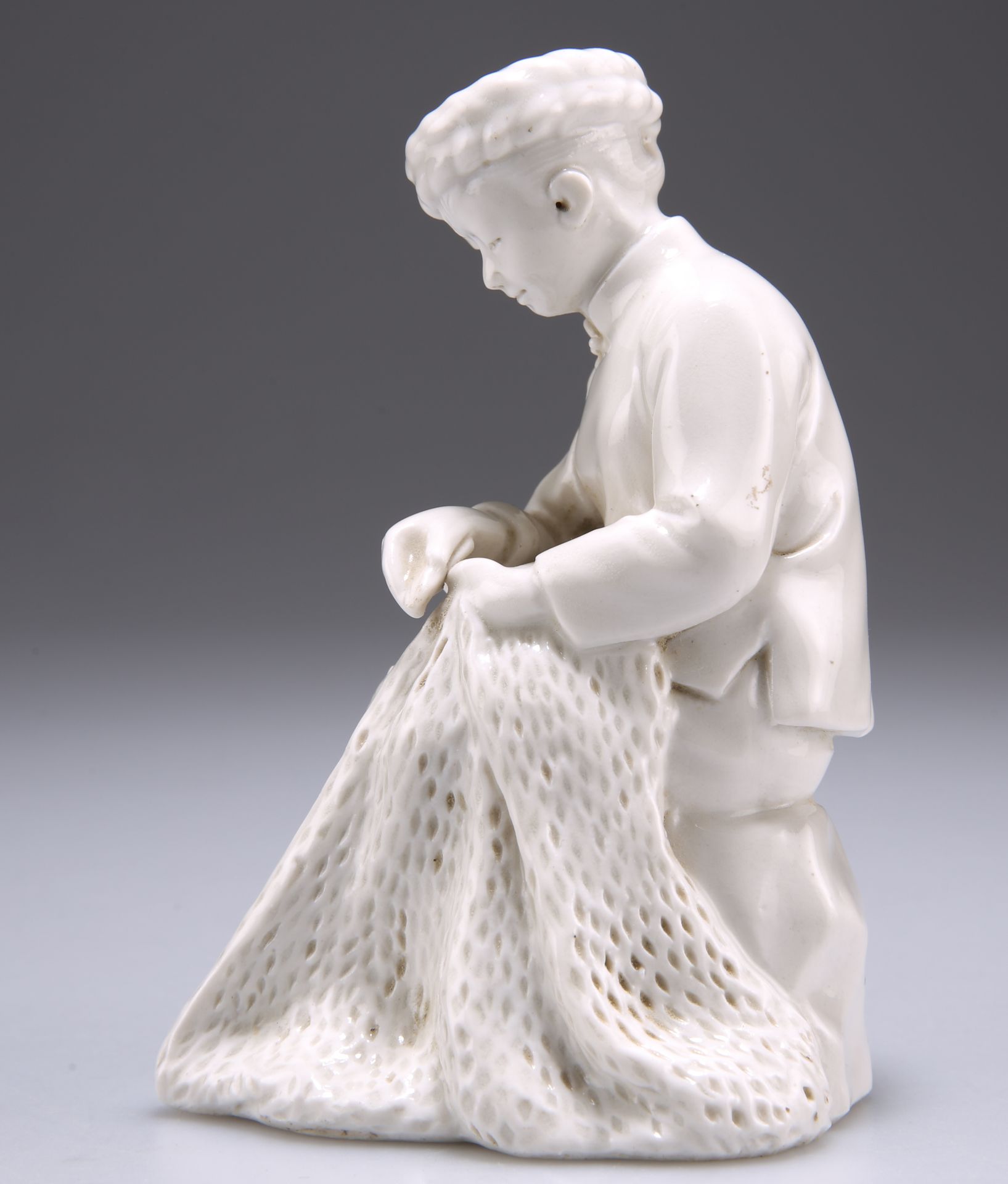 A BLANC DE CHINE FIGURE OF A SEATED WOMEN REPAIRING A FISHING NET - Image 2 of 4