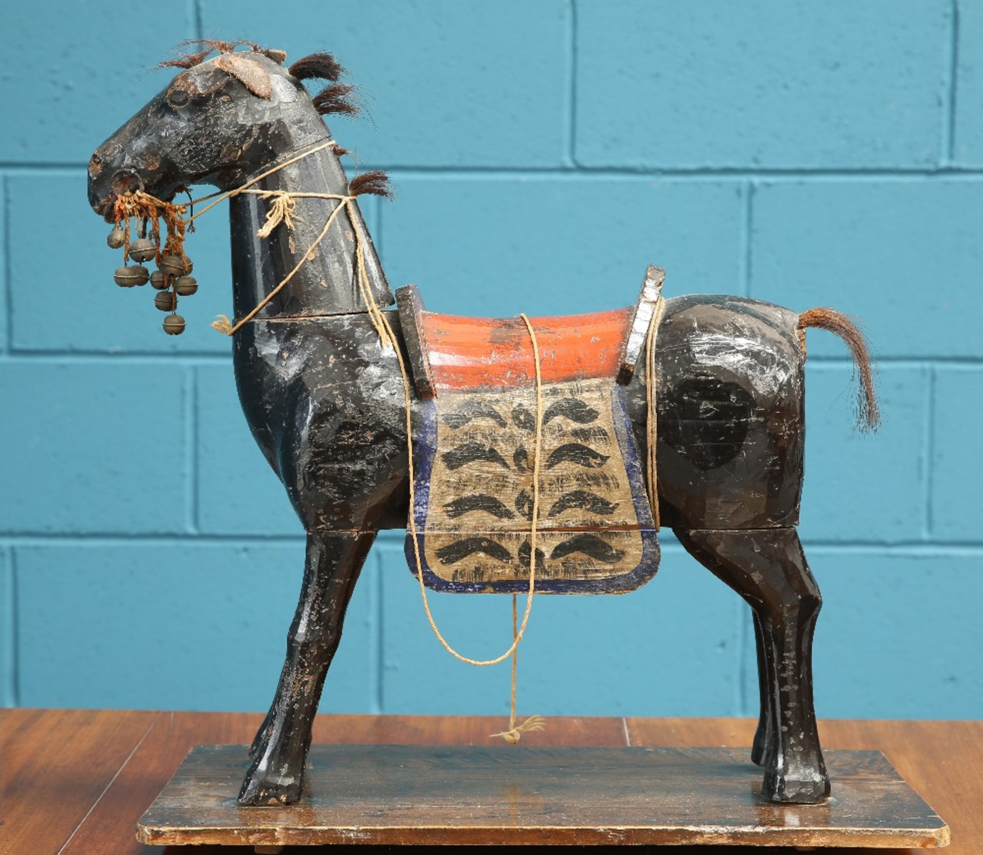 A 19TH CENTURY MIDDLE EASTEN CARVED AND PAINTED MODEL OF A HORSE